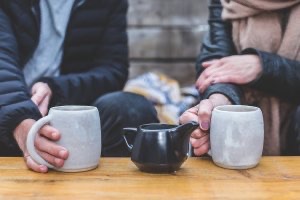 Unseen man and woman drinking coffee