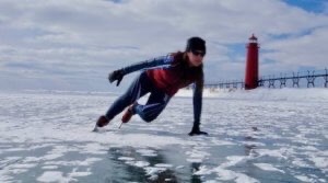 Ice skater on Lake Michigan near lighthouse