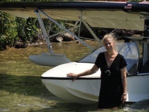 Innkeeper Deb Cannon standing in from of float plane on Torch Lake