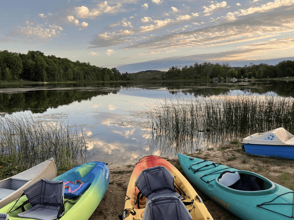 Canoes and kayaks in front of a lake