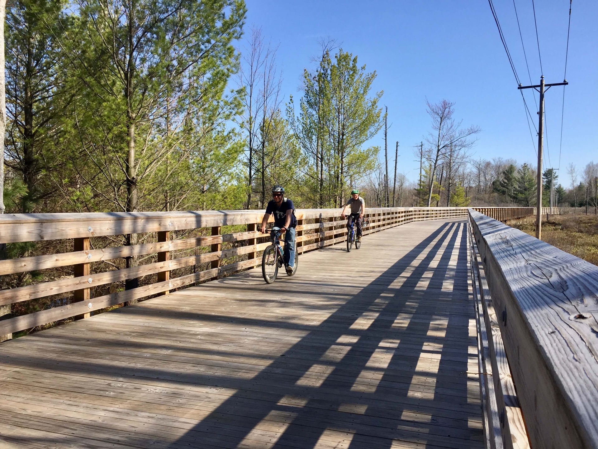 Two bike riders on an elevated section to Heritage Trail near Glen Arbor