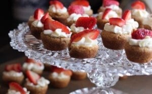 Strawberries top cupcakes sitting on a cut glass cake stand