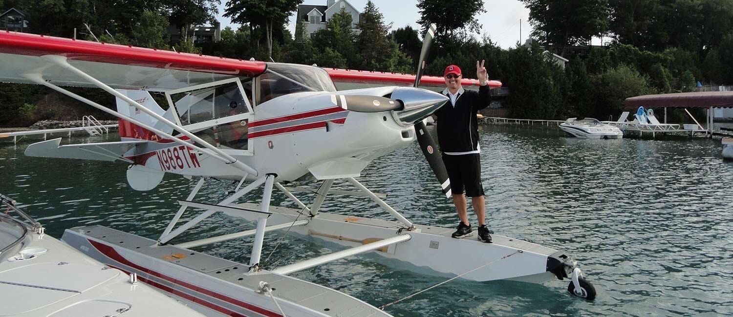 Man waves after landing his seaplane in Torch Lake at Torch Lake B&B
