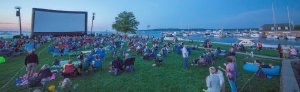 At dusk on Grand Traverse Bay in Traverse City, crowd waits for movie to begin during Traverse City Film Festival