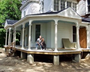 The Murphys, aspiring innkeepers sit on the unfinished front porch of what will be Port Austin Bed and Breakfast