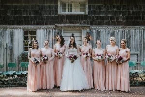 Bride and seven bridesmaids pose in front of an historic building on The Morris Estate