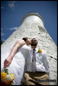 Wedding couple poses for photo in front of Old Presque Isle Lighthouse.
