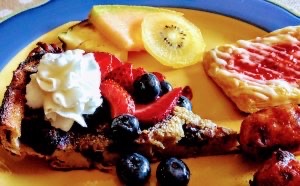 Dutch Baby entree at Shining Light Inn B&B with berries and whipped cream on top