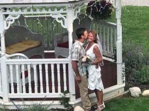 A newlywed couple kiss outside of the gazebo at Hexagon House in Pentwater