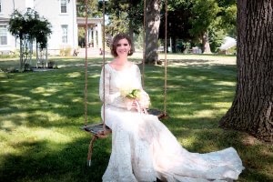 Bride sits on a swing with Villa on Verona in background