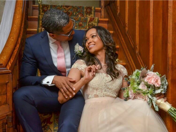 Couple sits on stairs at Historic Webster House B&B after their vows renewal