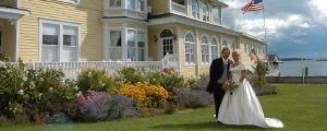 Newlyweds pose on the lawn next to Bay View B&B