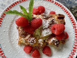 Baked French toast with raspberries and powdered sugar on top