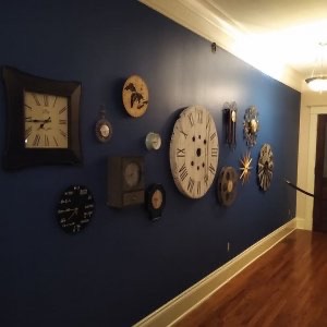 Dark blue walls accent a collection of clocks