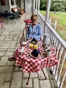 Liz at their breakfast table on the porch at House on the Hill B&B