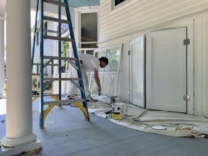 Painter works on trim at Port Austin Bed and Breakfast