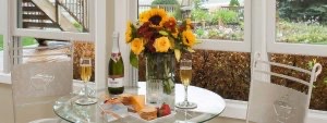 Flowers and champagne on a small table overlooking window at Huron House.