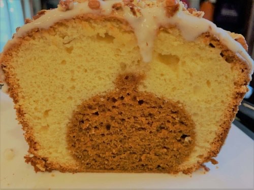A cross-section of a loaf of sweet bread reveals pumpkin-colored cake in the shape of a pumpkin.