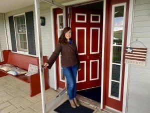 Innkeeper Marci Palajac stands at the front door of House on the Hill B&B in Ellsworth