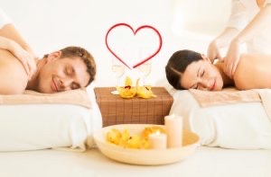 Couple lying face down head to head on massage tables