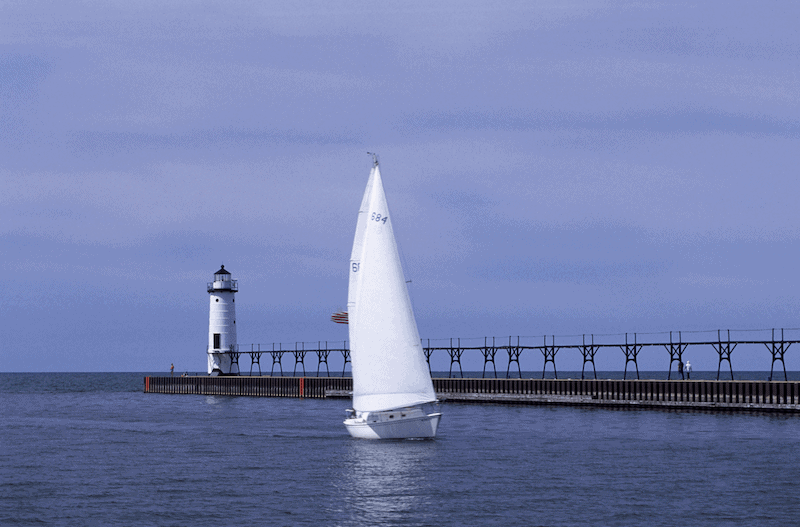 Manistee Harbor with a lighthouse and sailboat