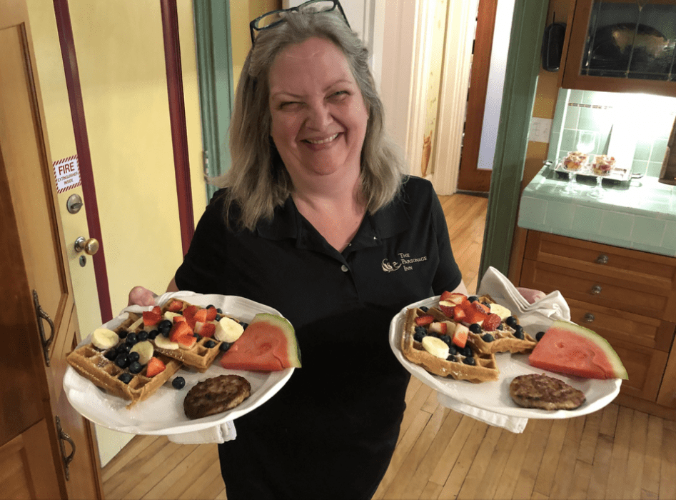 Woman serving two plates of breakfast