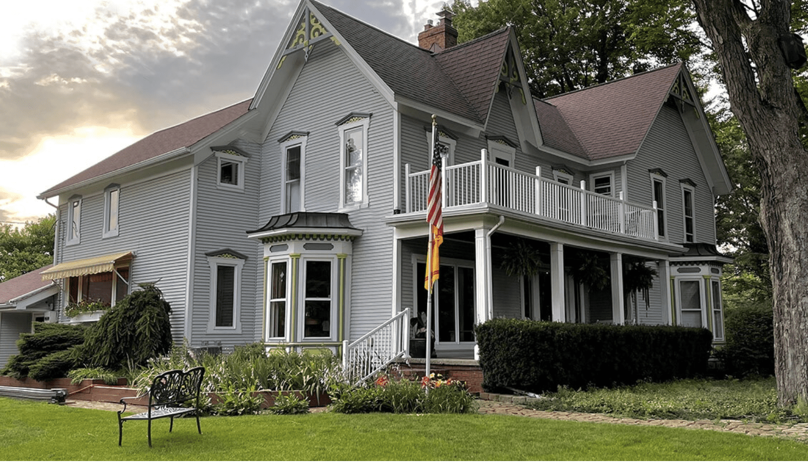 Grey Farmhouse with a porch and flag