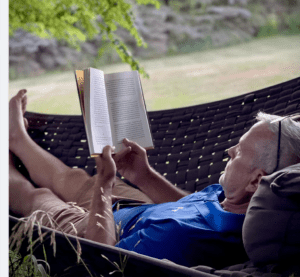Man relaxing in a chair while reading a book
