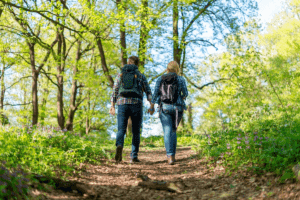 Couple holding hands while walking in the woods