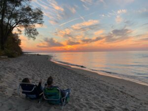 Couple sitting in chairs on the beach watching the sunset