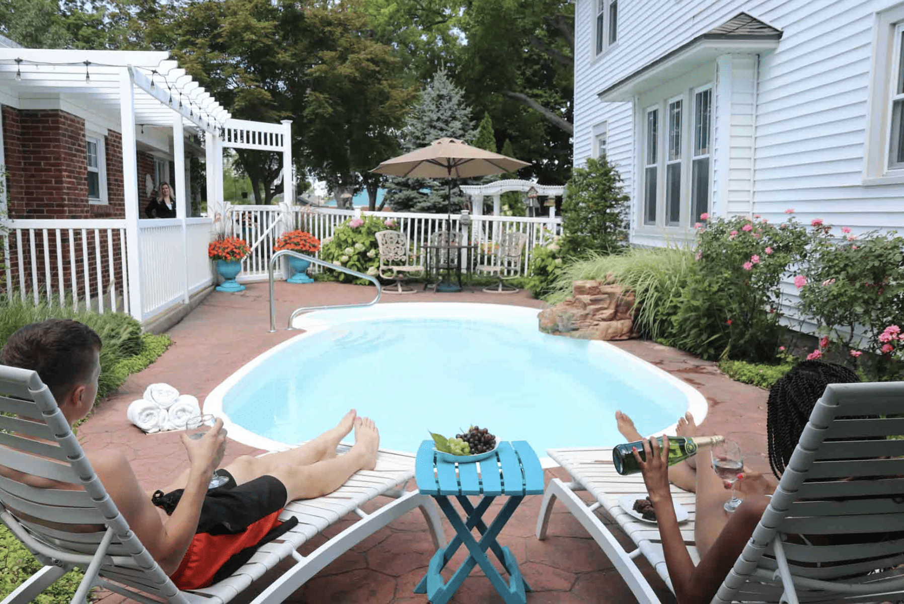 Couple relaxing by an outdoor pool at the PrairieSIde Suites
