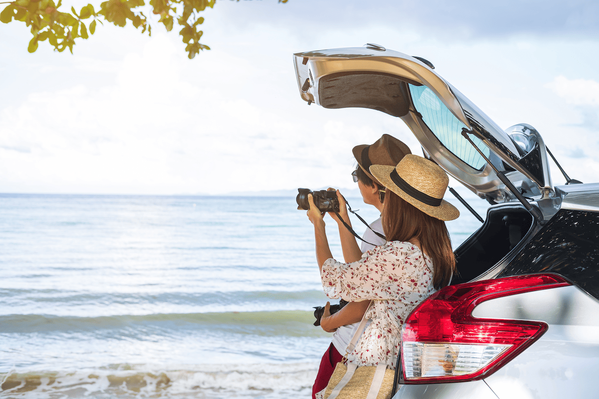 Couple with camera sitting on their tailgate looking at a beach for a Michigan Road Trips