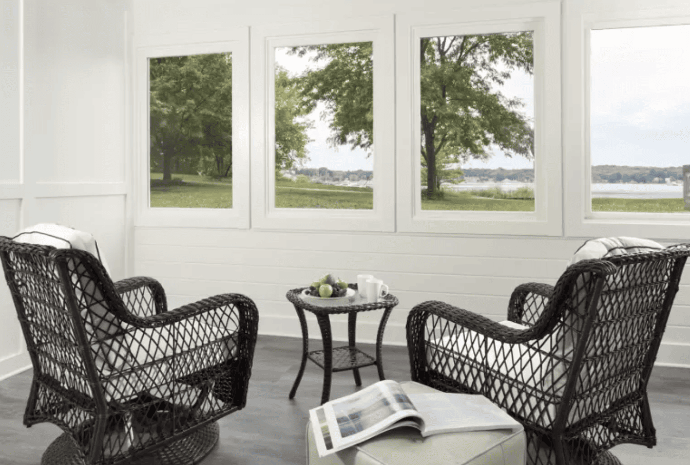 Two wicker chairs looking out of windows with a lake view