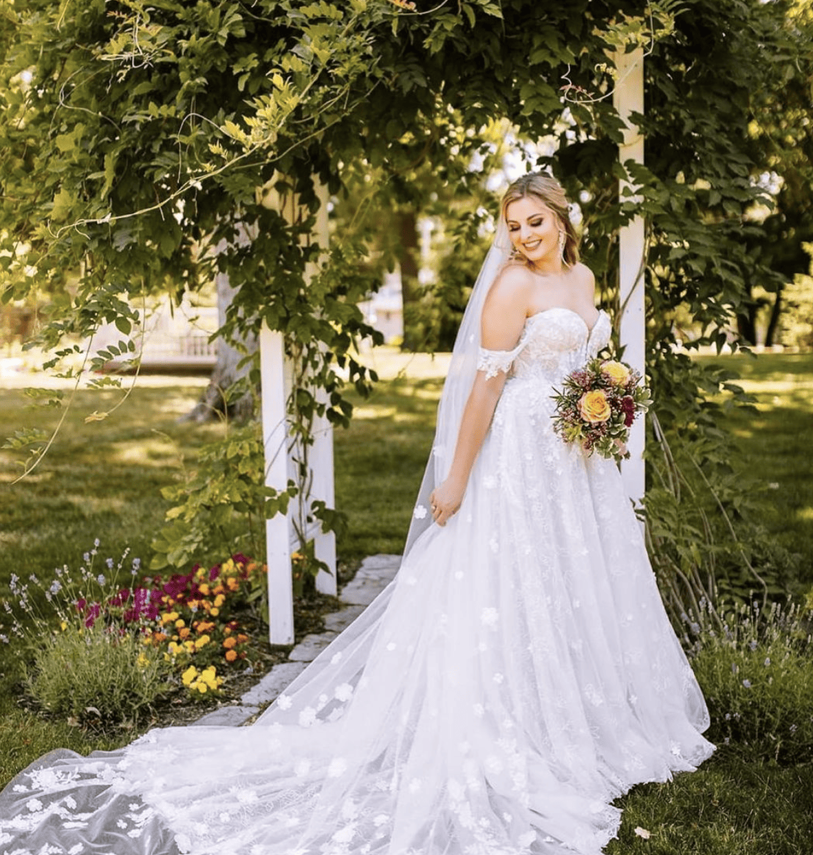 Bride standing next to a gazebo with a beautiful train