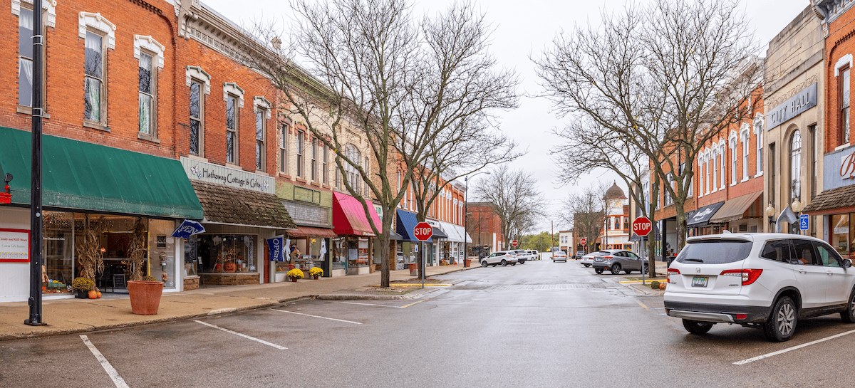 a picture taken of downtown Allegan with shops and awnings