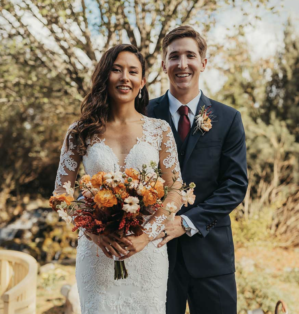 Wedding couple with beautiful bouquet in a garden