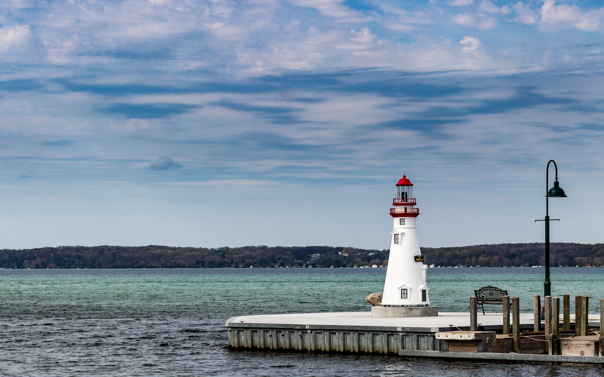 Small white lighthouse on a pier on Torch Lake