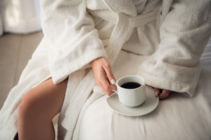 Woman in a white bathrobe with a cup of coffee