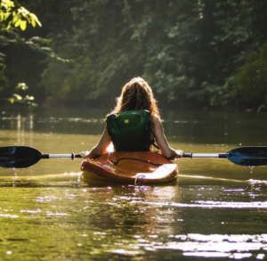 Woman kayaking on the river in a red kayak