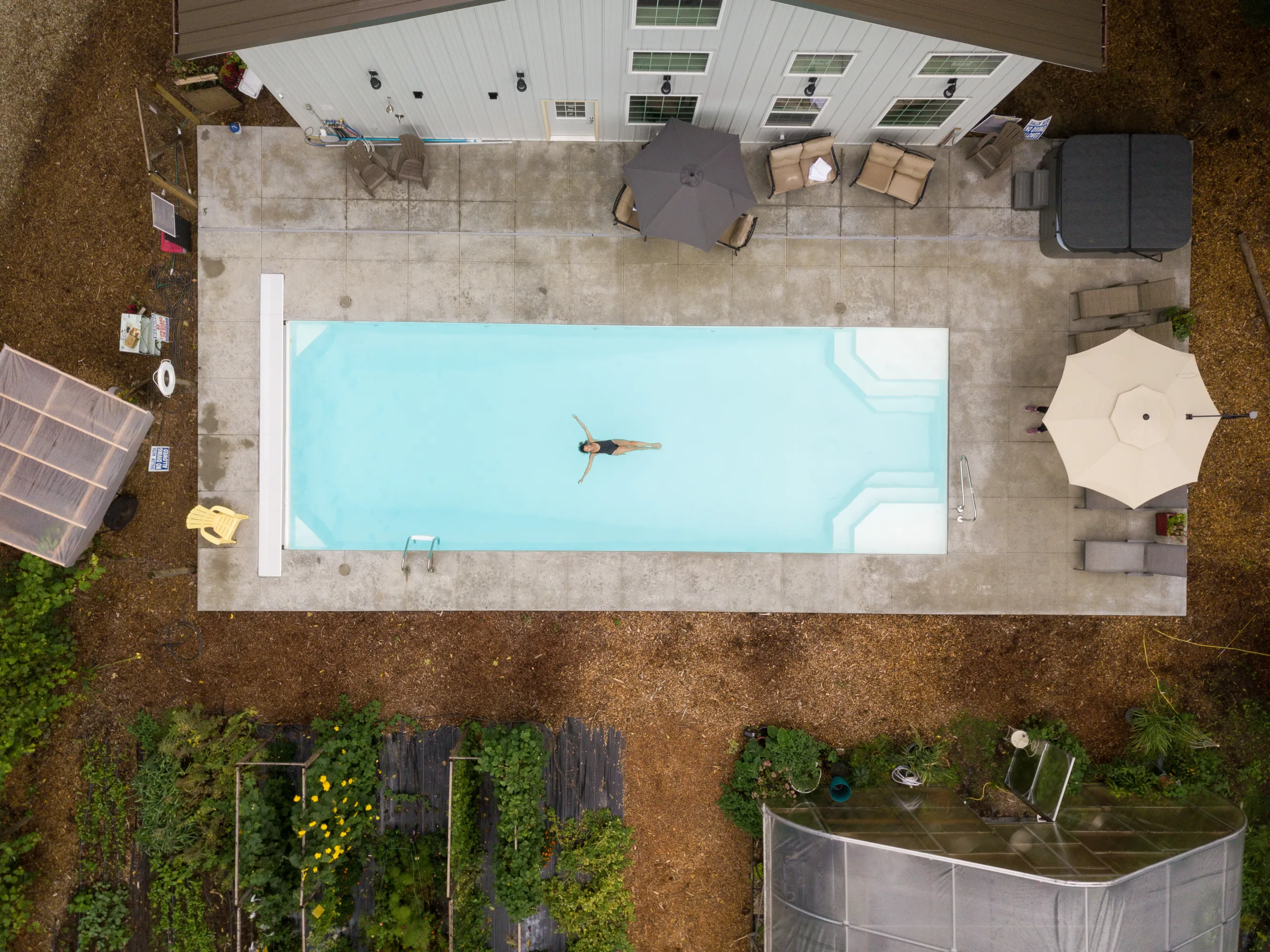 Aerial shot of a woman floating in a pool